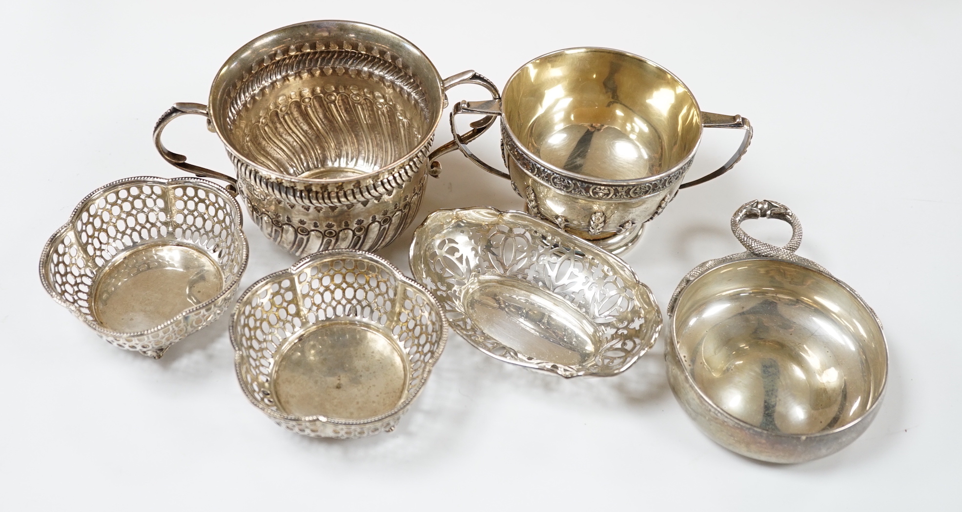 An Edwardian repousse silver porringer, Daniel & John Welby, London, 1905, diameter 92mm, a pair of pierced silver bonbon dishes, one other similar bonbon dish, a silver two handled bowl and a modern silver taste vin